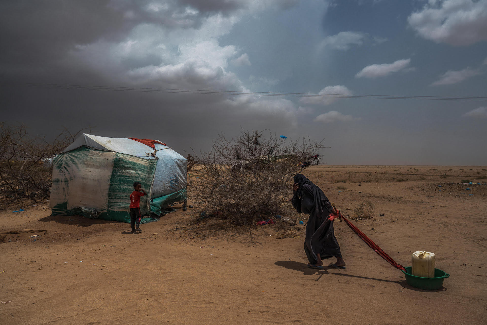 atlante delle guerre Khamir Idp Settlement, Khamir – 4 maggio 2017. Una donna sfollata trascina l’acqua nella sua tenda. ©Giles Clarke:WARS Winner 2021