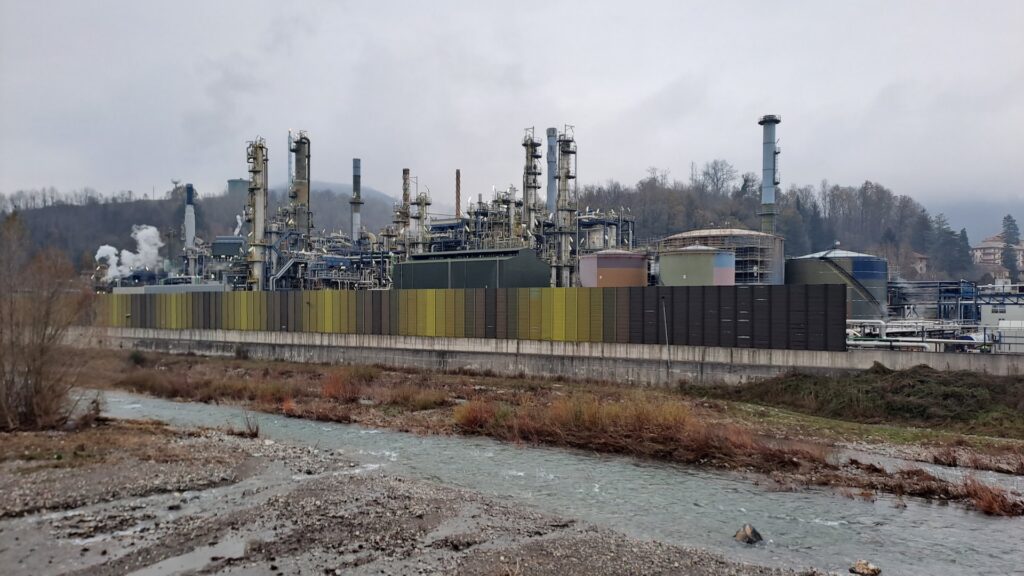Raffineria IPLOM di Busalla in Liguria: impianti, ciminiere e serbatoi sul lato destro del torrente Scrivia, sotto cielo grigio