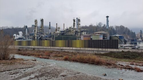 Raffineria IPLOM di Busalla in Liguria: impianti, ciminiere e serbatoi sul lato destro del torrente Scrivia, sotto cielo grigio