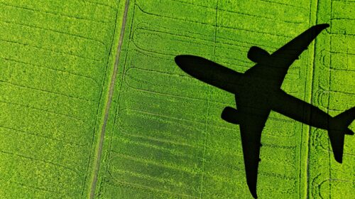 Ombra di un aereo su un campo verde, simbolo delle emissioni dei voli per la Coppa del Mondo 2026