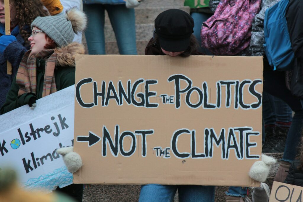 Manifestante per il clima con un cartello «Change the politics, not the climate», contro il negazionismo della classe politica durante l'ondata di caldo