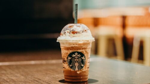 Bicchiere di plastica Starbucks con frappuccino e cannuccia su un tavolo