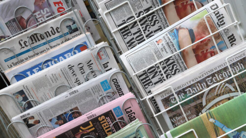 Edicola con quotidiani internazionali, simbolo del calo di copertura mediatica della crisi climatica
