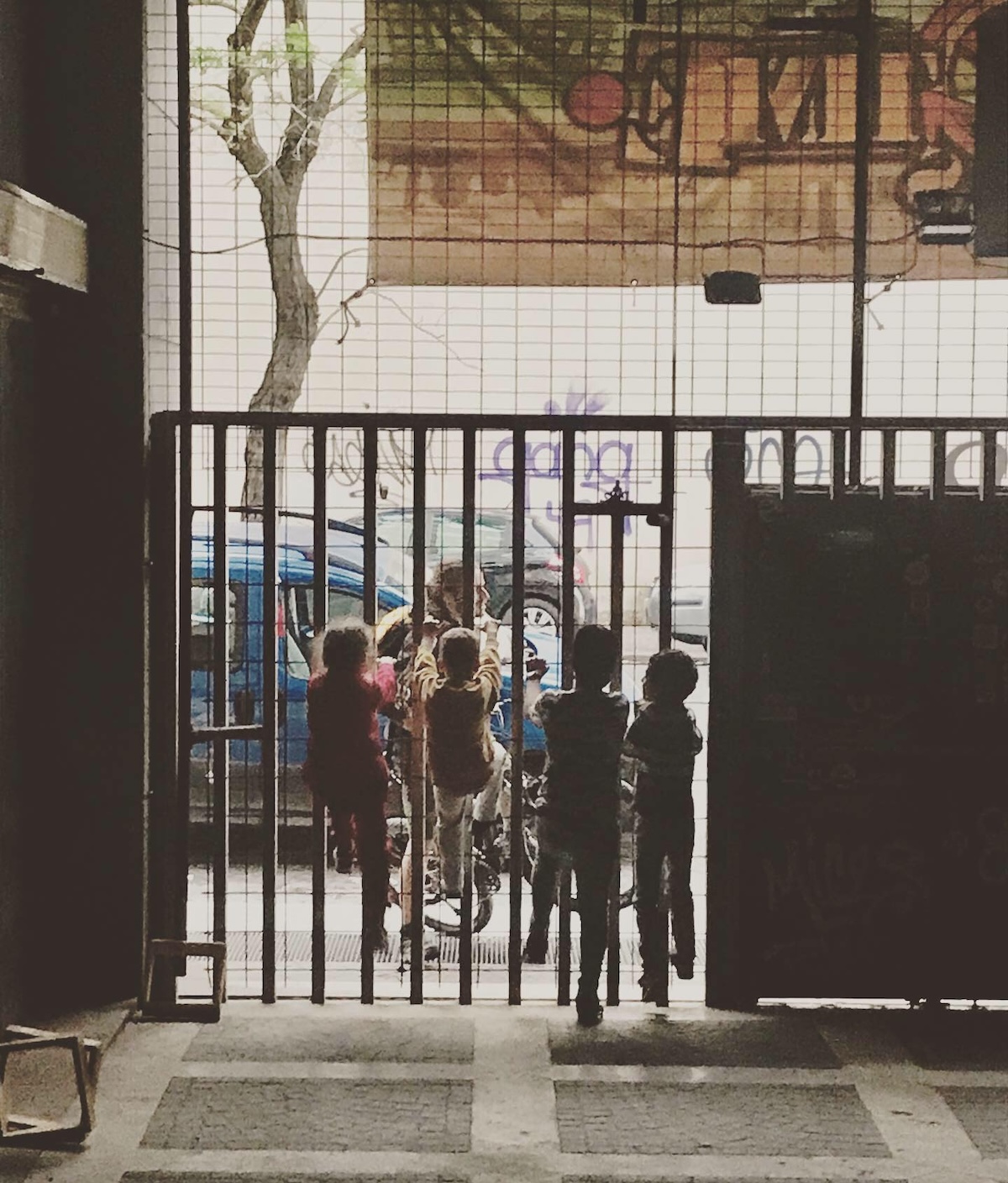 Bambini affacciati al cancello dell'edificio occupato di Spin Time