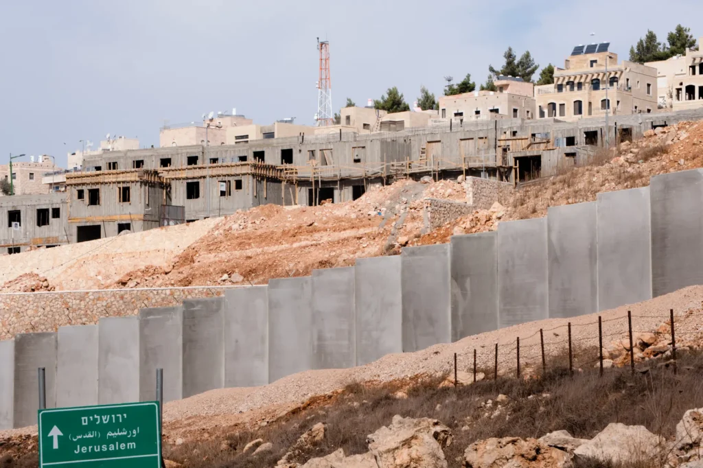 Costruzione di un insediamento israeliano in Cisgiordania dietro il muro di separazione