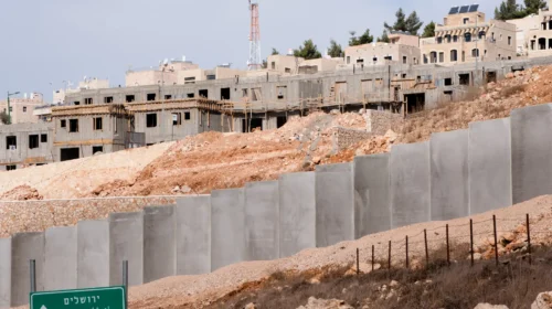 Costruzione di un insediamento israeliano in Cisgiordania dietro il muro di separazione