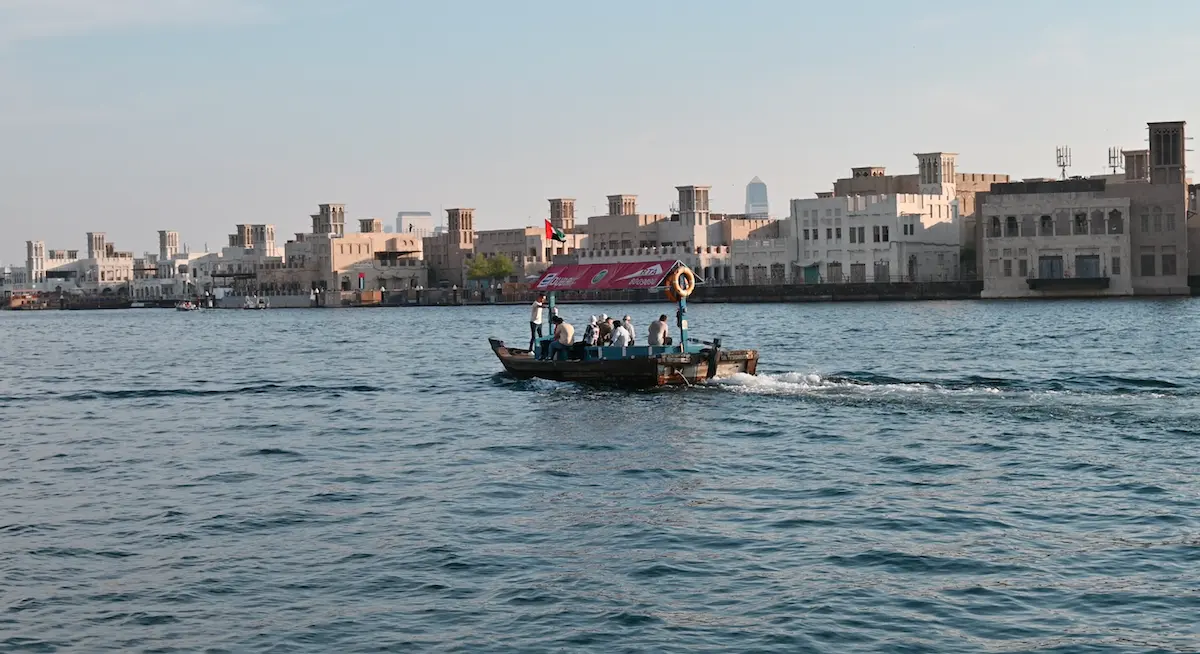 Abra, il traghetto tradizionale del Dubai Creek, con le torri del vento della città vecchia sullo sfondo