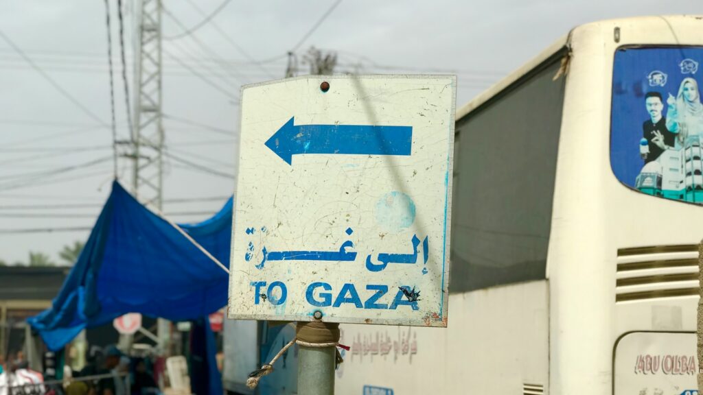 Cartello stradale con la scritta «To Gaza» in inglese e arabo accanto a un autobus